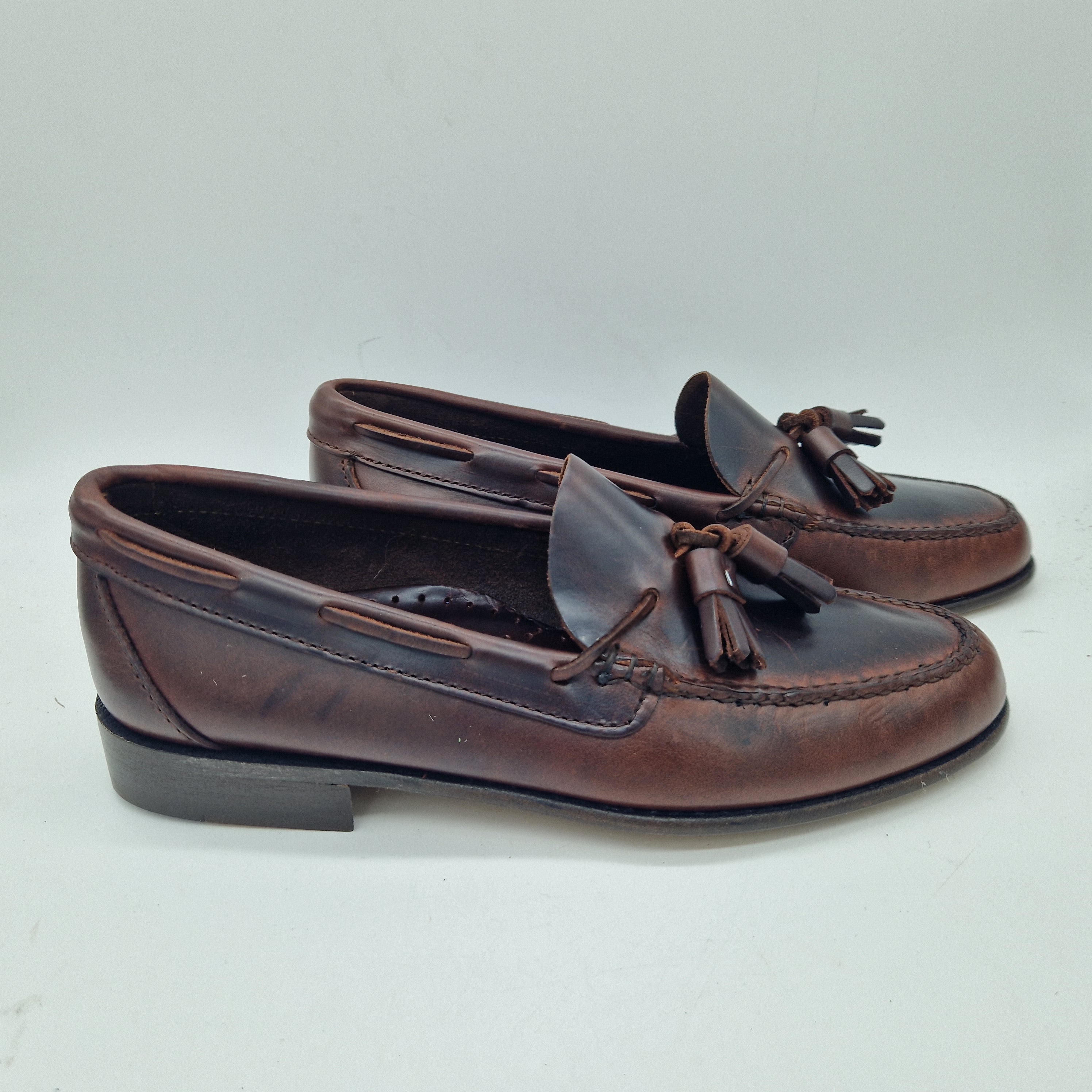 Mocasines 1901 con borlas en piel marrón, calzado elegante para hombre, detalles en la parte superior.