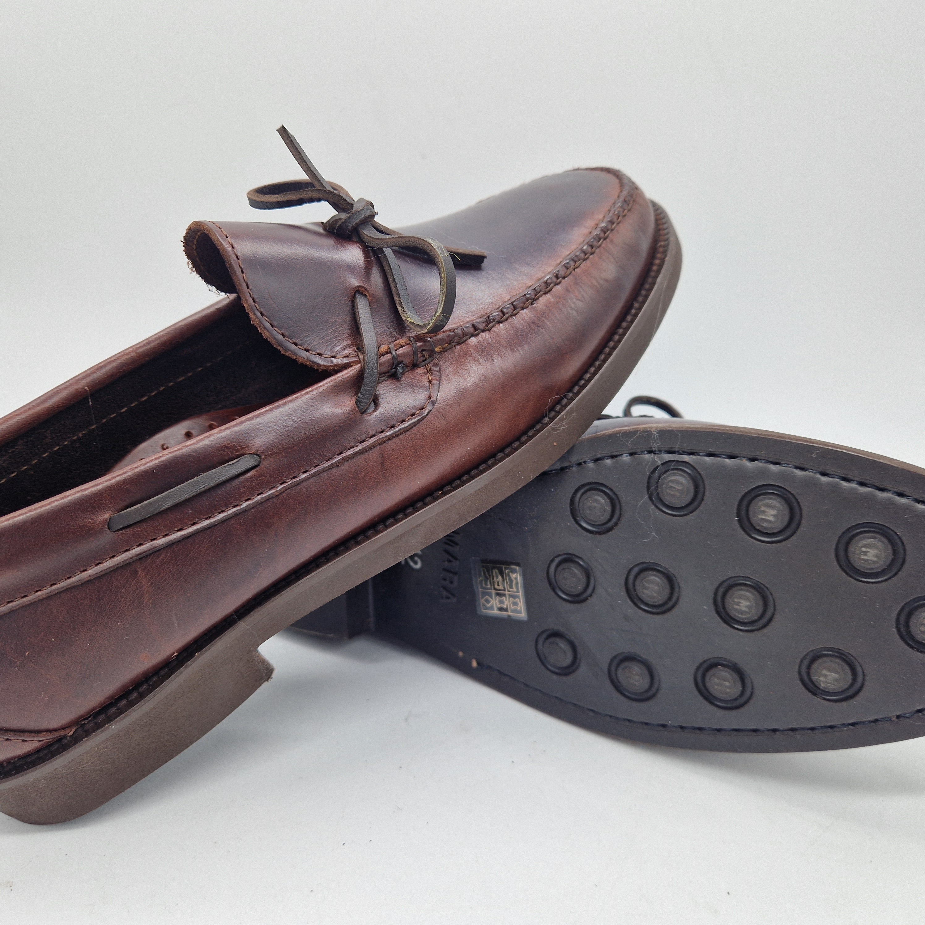 Mocasines marrón de piel con lazo de la marca Mocasines 1901, detalles de botones en el diseño del calzado.