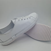 Zapatillas deportivas en piel blanca de Calzados Cremades, con detalles en azul y suela blanca.