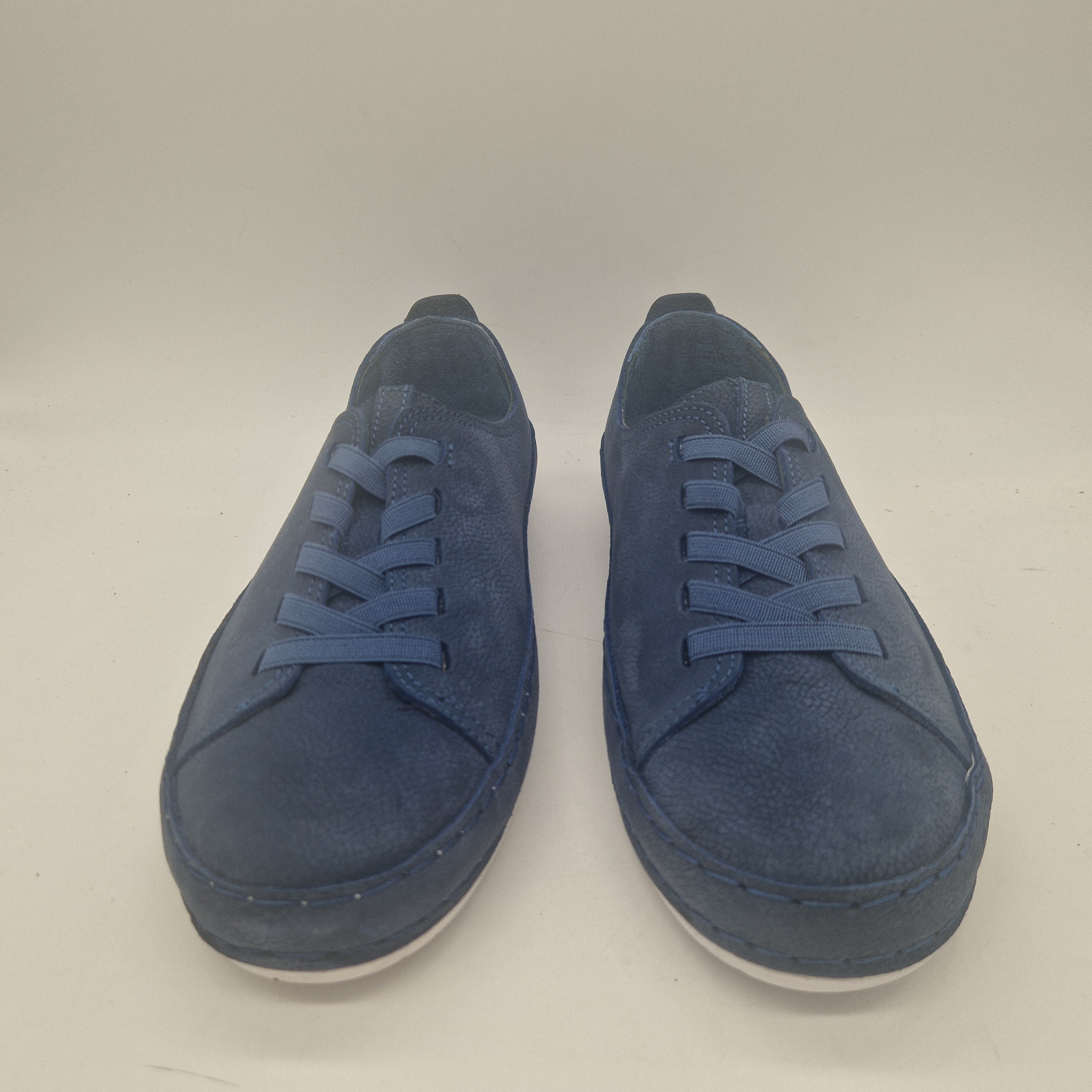 Deportivos en nobuck azul marca Calzados Cremades, vista lateral con suela blanca y detalles en tonos oscuros.