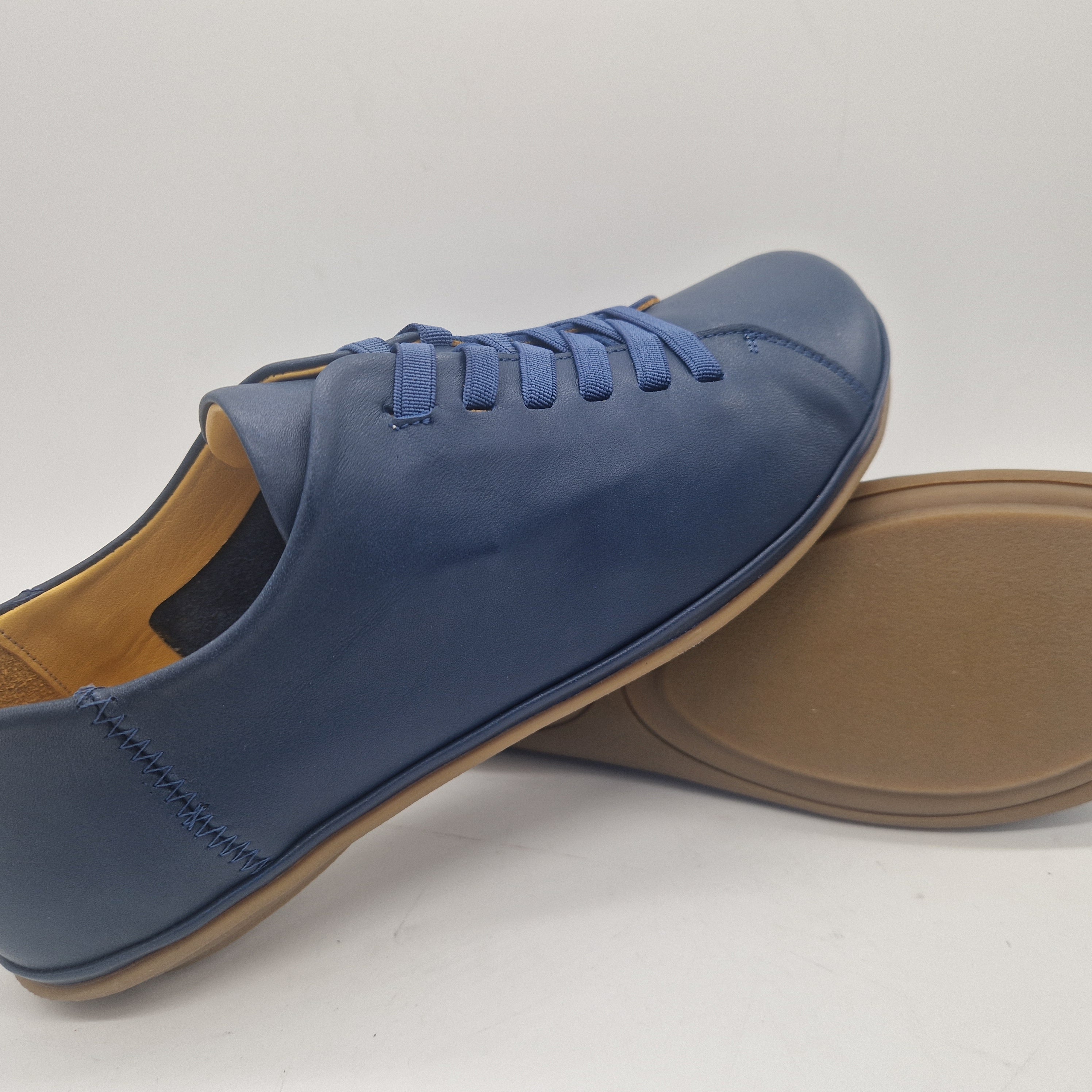 Zapatos deportivos en piel azul marino de Calzados Cremades, vista lateral con detalles en la parte superior.