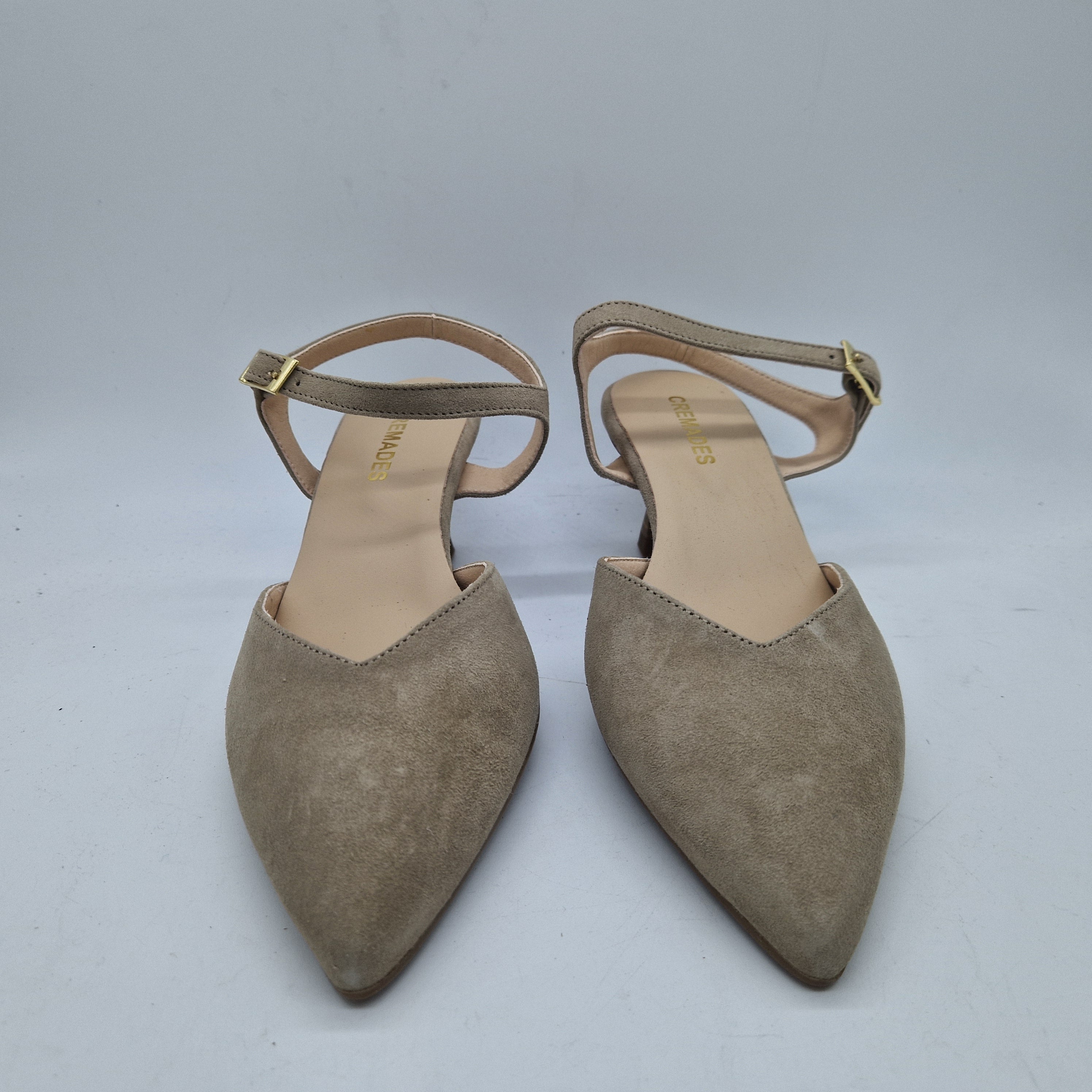 Sofá destalonado en serraje taupe de la marca Kroc, con cojines y estructura moderna para salón elegante.