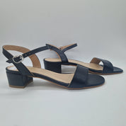Sandalia baja en piel negra de Calzados Cremades, con tiras y suela plana, perfecta para un estilo casual y cómodo.