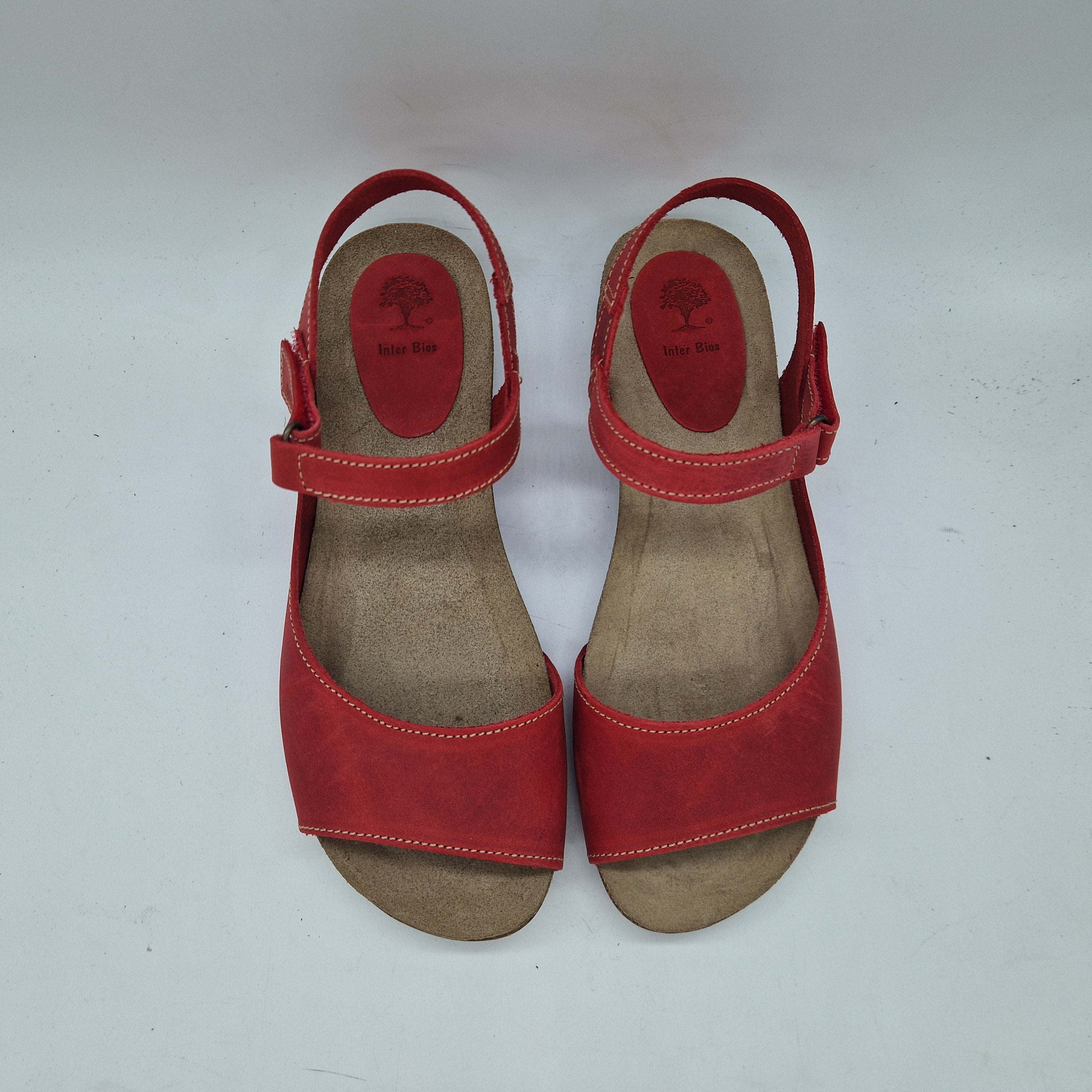 Sandalias en piel roja de la marca Interbios, con tiras elegantes y suela cómoda, ideales para el verano.