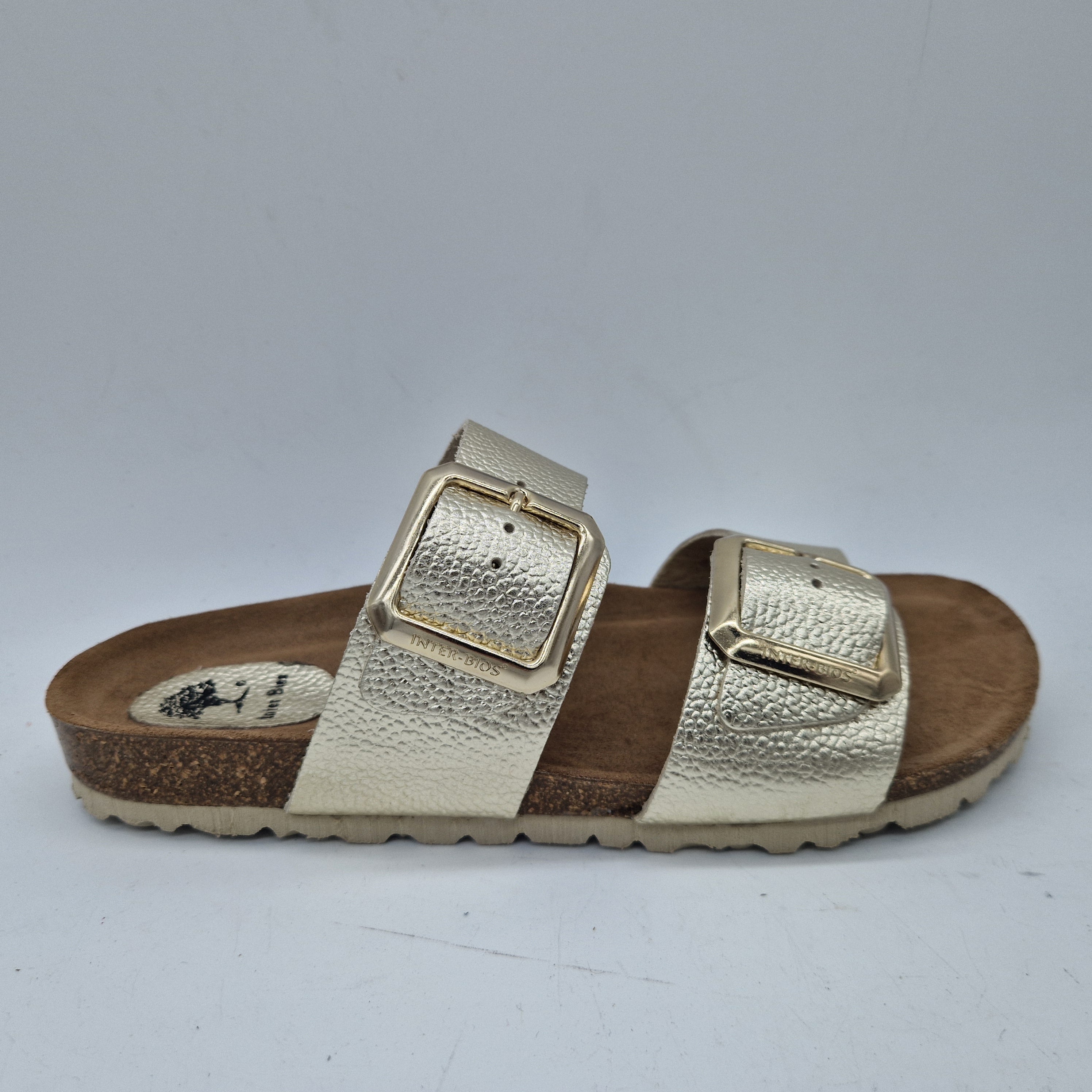 Sandalias Interbios de 2 hebillas en color platino, con diseño elegante y acabado brillante.