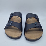 Sandalias Interbios de dos hebillas en marrón, con suela de piso fino y cómodo, ideales para verano y uso casual.