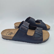 Sandalias Interbios de dos hebillas en marrón, con piso fino, vistas desde un ángulo que muestra las correas y el diseño elegante.