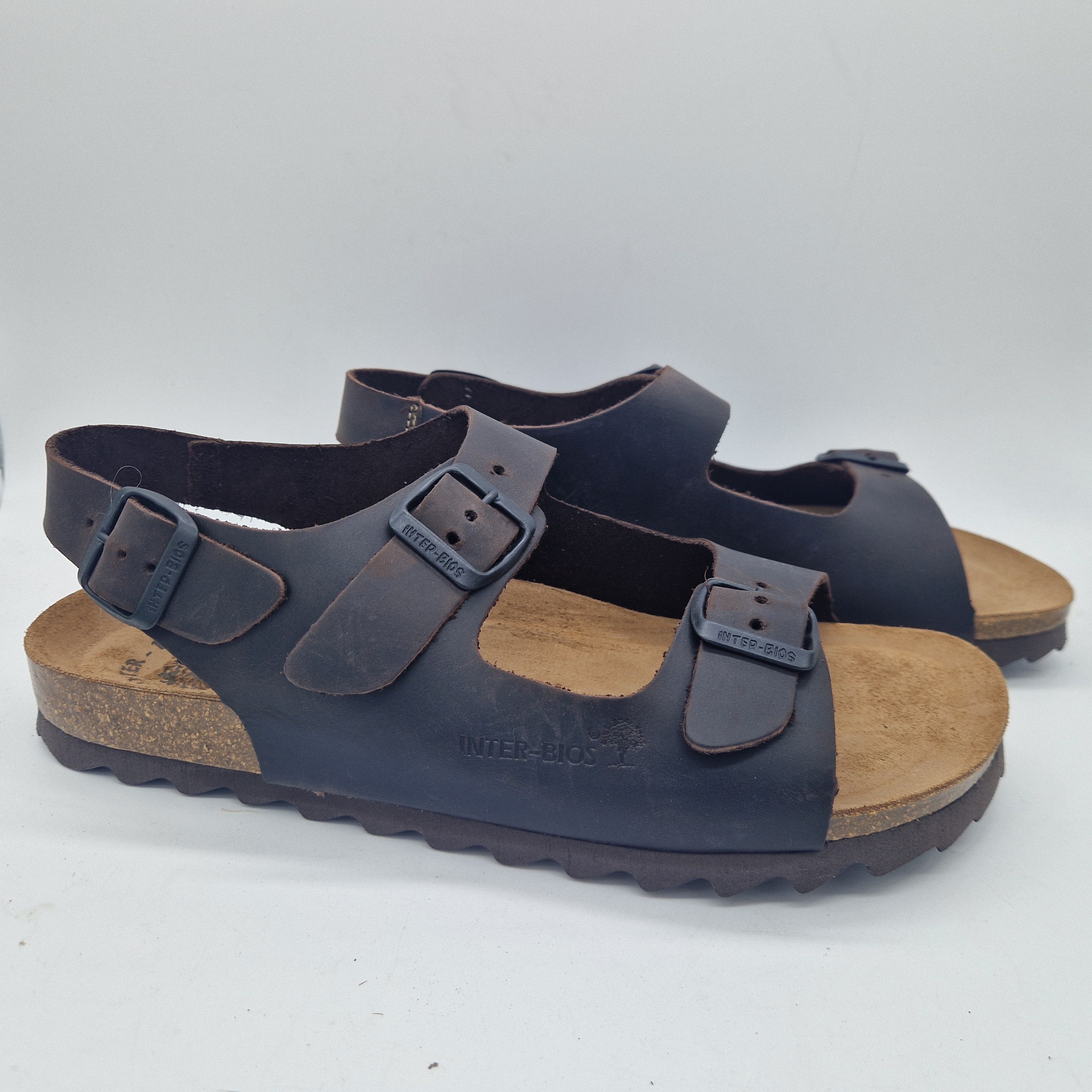 Sandalias Interbios de dos hebillas y trasera en color marrón, con diseño cómodo y elegante para mujer.