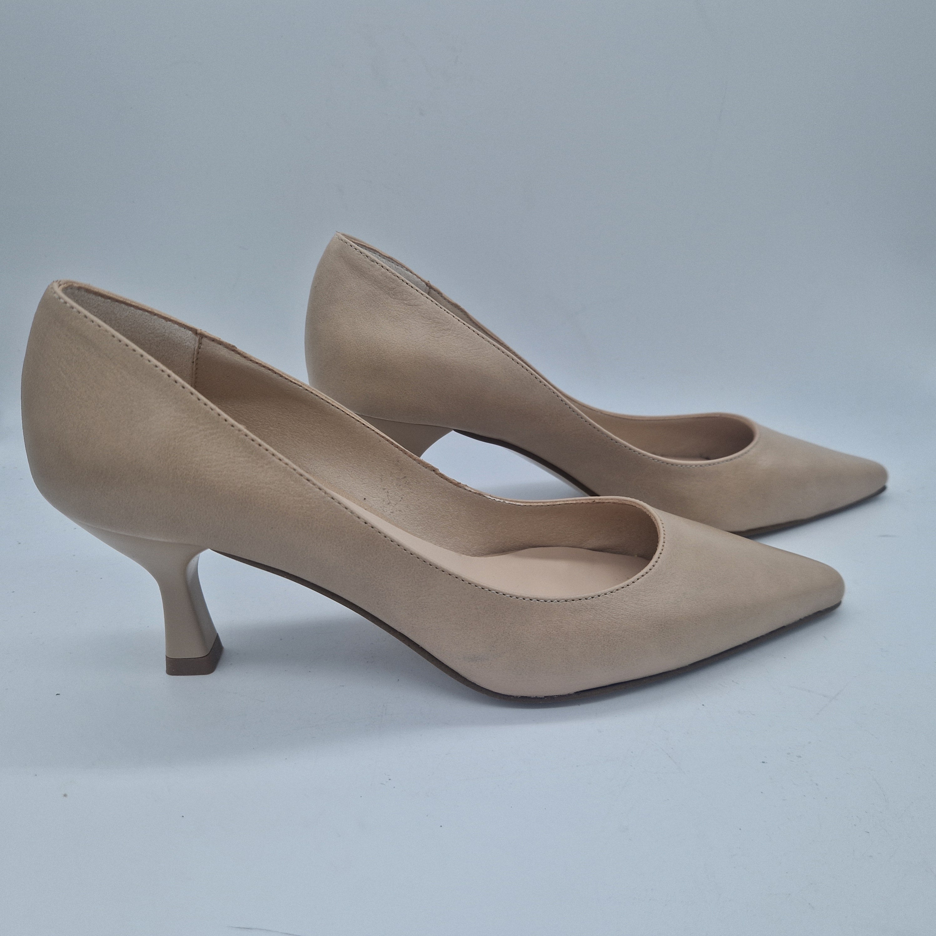 Sofá en piel color nude de Patricia Miller, estilo salón con cojines y estructura moderna, visible en la imagen.