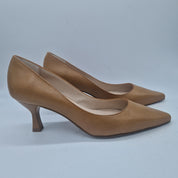 Sofá en piel color camel de la marca Patricia Miller, con cojines y diseño elegante para sala de estar.