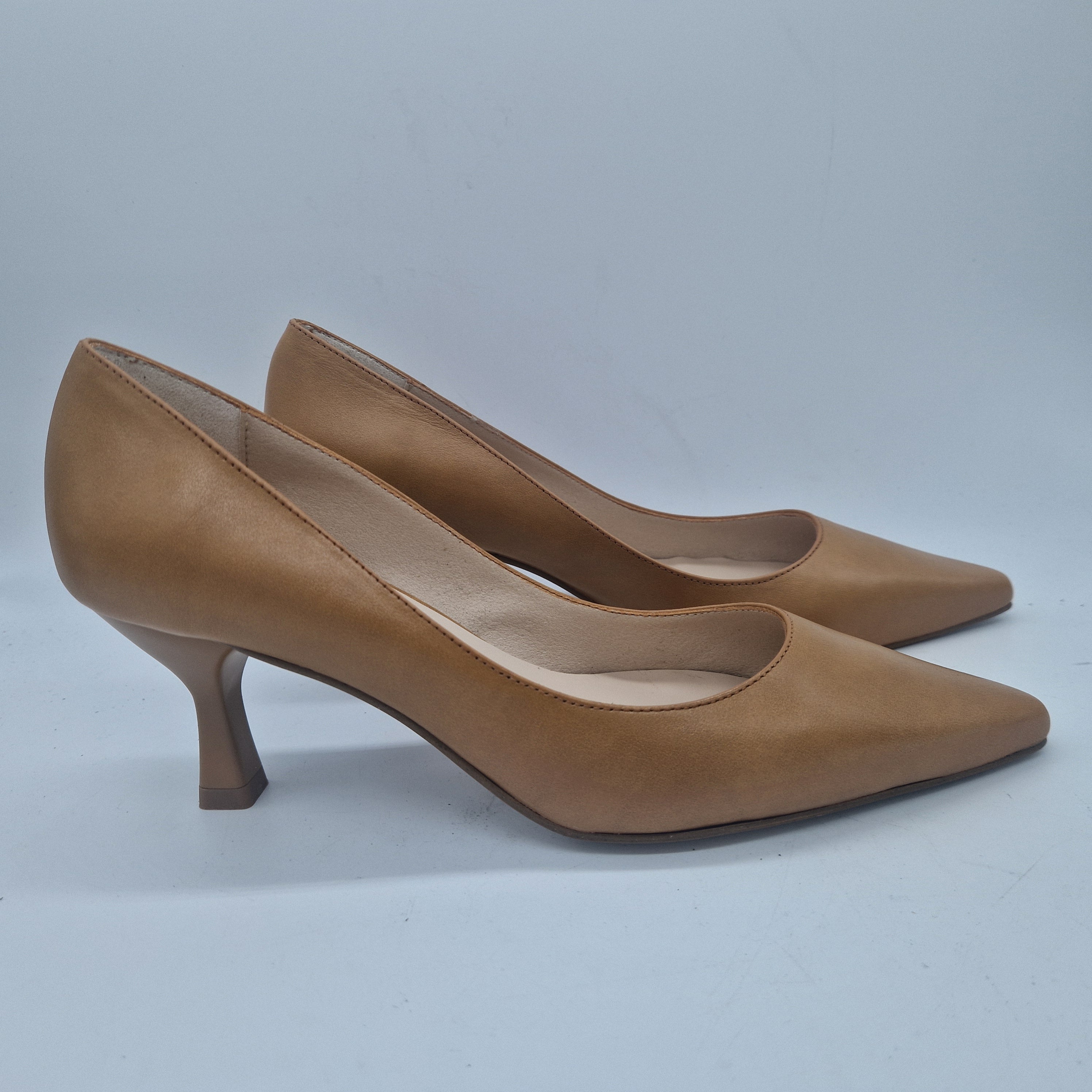 Sofá en piel color camel de la marca Patricia Miller, con cojines y diseño elegante para sala de estar.