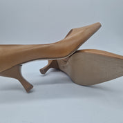 Sofá salón en piel color camel de Patricia Miller, con cojines y estructura moderna en un entorno elegante.